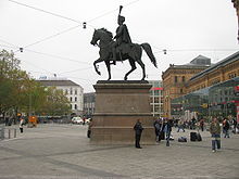 Statue of Ernest Augustus I in front of the Hannover Hauptbahnhof. Bystanders meet "under the tail".