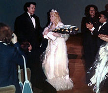 Cooper (second from right) laughs at Mae West's words after the opening of her last movie in 1978.