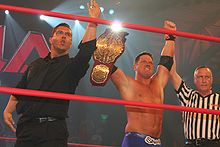 Kazarian celebrating with A.J. Styles in July 2010