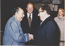 Ford and his daughter Susan watch as Henry Kissinger shakes hands with Mao Zedong, December 2, 1975