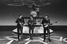 Lennon (right) performing with the Beatles in 1964 at the height of Beatlemania