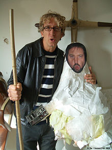 Dick holding a piñata with a cutout of Tom Green for The 1 Second Film in December 2004
