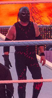 Kane in 2012, making his entrance at WrestleMania XXVIII, wearing the metallic mask over his red mask.