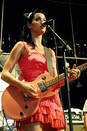 Performing on her guitar, an instrument she learned to play when she was just starting her recording career