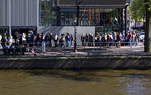 People waiting in line in front of the Anne Frank House entrance in Amsterdam