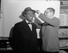 Armstrong getting fitted for a hat, about 1955.