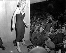 Monroe poses for soldiers in Korea after a USO performance at the 3rd U.S. Inf. Div. area, February 17, 1954.
