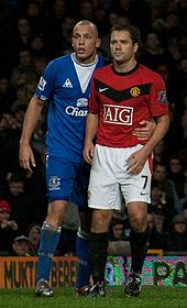 Owen (right) playing for Manchester United, with Everton's John Heitinga.