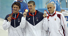 Phelps holds his gold medal on the podium on August 10, 2008. Pictured with Ryan Lochte and László Cseh