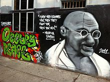 A wall graffiti in San Francisco containing a quote and image of Gandhi