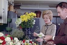 Pat works with a florist on flower settings, December 1970