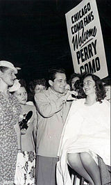 Arriving in Chicago for performances in 1947, Como is met by his young fans, who get a trim along with a song.