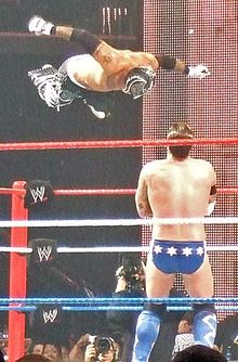 Mysterio attempting a flying headbutt from the top rope on CM Punk.
