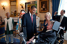 U.S. President Barack Obama talks with Stephen Hawking in the Blue Room of the White House before a ceremony presenting him and 15 others with the Presidential Medal of Freedom on 12 August 2009.