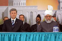 Stephen Harper (left) seated with Ahmadiyya leader Mirza Masroor Ahmad (right) at the grand opening of Baitun Nur, the largest mosque in Canada. (July 5, 2008)