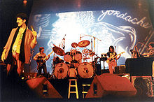 Steve Vai (on guitar in between the drums and keyboard), Frank Zappa and band during a concert at the Memorial Auditorium, Oct 25, 1980 Buffalo, New York