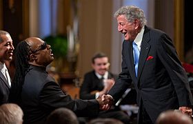 Bennett greets Stevie Wonder at the White House on February 25, 2009.