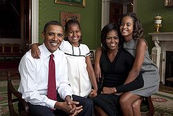 Obama posing in the Green Room of the White House with wife Michelle and daughters Sasha and Malia in 2009