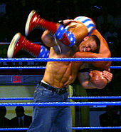 Cena performing an "FU" (standing fireman's carry takeover) on Kurt Angle in January 2005.