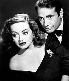 Davis posing as Margo Channing in a promotional image for All About Eve (1950). She is pictured with Gary Merrill, to whom she was married from 1950 to 1960 (her fourth and final husband)