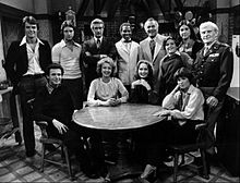 Billy Crystal (seated at left of table) as Jodie Dallas in a 1977 promotional photo of the premiere for the TV sitcom Soap.