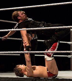 Bryan performing a surfboard on Dean Ambrose.