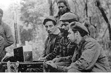 Listening to a Zenith Trans-Oceanic shortwave receiver are (seated from the left) Rogelio Oliva, José María Martínez Tamayo (known as "Mbili" in the Congo and "Ricardo" in Bolivia), and Guevara. Standing behind them is Roberto Sánchez ("Lawton" in Cuba and "Changa" in the Congo), 1965.