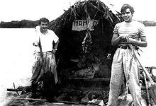Guevara (right) with Alberto Granado (left) aboard their "Mambo-Tango" wooden raft on the Amazon River in June 1952. The raft was a gift from the lepers whom they had treated.[38]