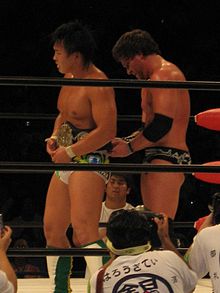 Sabin (right) fastening the AJPW World Junior Heavyweight Championship around the waist of Katsuhiko Nakajima, after Nakajima had defeated Sabin to retain it in August 2007.