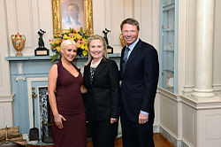 Hillary Clinton (center) and David Novak (right) presented Aguilera (left) with the George McGovern Leadership Award in October 2012 for her outstanding contributions to the United Nations World Hunger Relief effort[302][303]