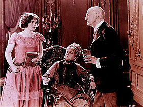 Bow as "Janet", the "horrid" flapper in Black Oxen (1923), holding Flaming Youth to her chest; with Kate Lester and Tom Ricketts