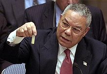 Colin Powell holding a model vial of anthrax while giving a presentation to the United Nations Security Council